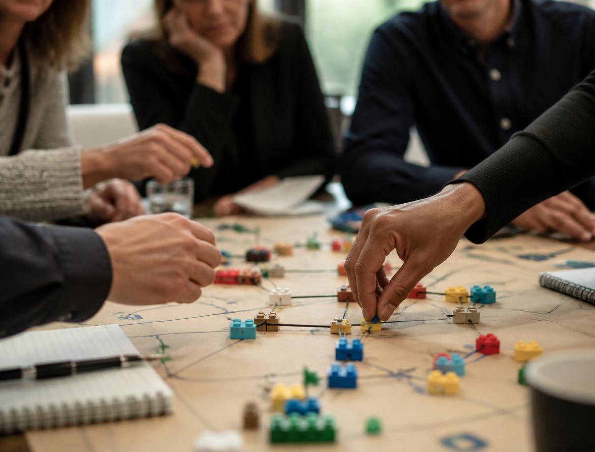 Hands building and connecting models in a strategy landscape